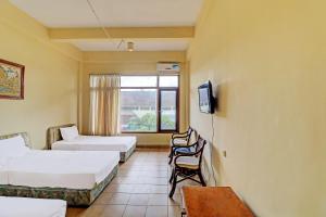 um quarto de hotel com duas camas e uma televisão em SUPER OYO 91870 Warna Kedaton em Denpasar