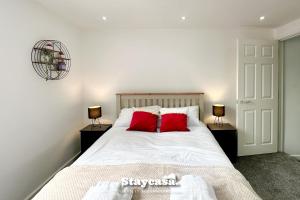 a bedroom with a bed with two red pillows at Stunning 3bdr 2ba House With Free Street Parkin in Birmingham