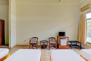 um quarto com duas camas e uma mesa e cadeiras em SUPER OYO 91870 Warna Kedaton em Denpasar
