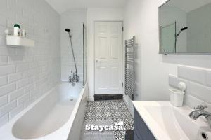 a white bathroom with a tub and a sink at Stunning 3bdr 2ba House With Free Street Parkin in Birmingham