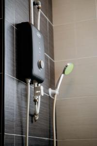 eine Dusche mit Telefon an der Wand eines Badezimmers in der Unterkunft Mount Austin Muji Style 4pax Deluxe Room by Our Stay in Johor Bahru