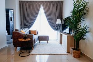 ein Wohnzimmer mit Sofa und Fernseher in der Unterkunft Mount Austin Muji Style 4pax Deluxe Room by Our Stay in Johor Bahru