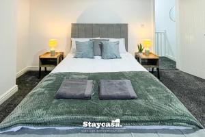 ein Schlafzimmer mit einem großen Bett mit zwei Nachttischen in der Unterkunft Live In Style House In Desirable Location in Manchester