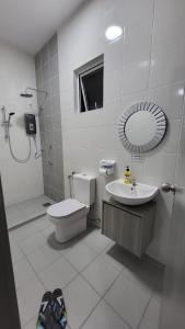 a bathroom with a toilet and a sink and a mirror at RHR Deluxe GuestHouse Kinarut Papar Sabah - Mountain View in Papar