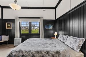 a bedroom with a large bed and a window at Farmhouse Charm - Coastal Comforts and Country Views in Cowes