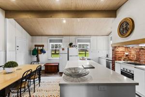 a kitchen with white appliances and a wooden ceiling at Farmhouse Charm - Coastal Comforts and Country Views in Cowes +22 photos