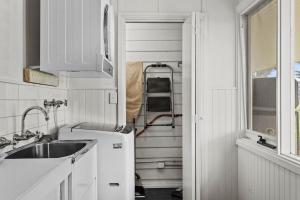 a kitchen with white cabinets and a sink at Farmhouse Charm - Coastal Comforts and Country Views in Cowes