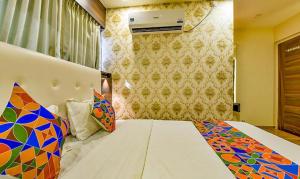 een slaapkamer met een bed met een kleurrijk dekbed bij FabHotel Raj Palace I in Vadodara
