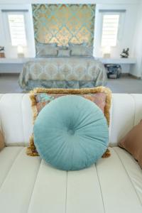 una almohada azul sentada en la parte superior de un sofá blanco en La Perla Bianca - 1 BR Beachfront Luxury Villa offering utmost privacy en Les Terres Basses