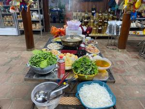 einen Tisch mit Lebensmitteln mit Schalen aus Gemüse und anderen Lebensmitteln in der Unterkunft Homestay-Nhà Sàn Ngán Chải in Ha Giang