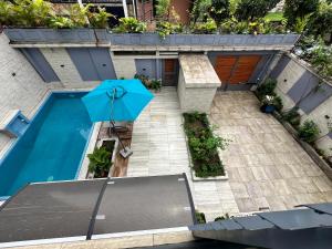 a blue umbrella sitting next to a swimming pool at Villa Only in Douala