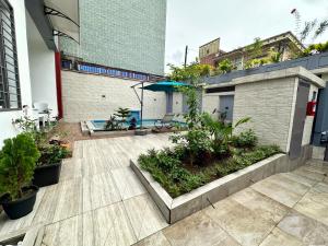 ドゥアラにあるVilla Onlyの建物内のパティオ(植物、傘付)