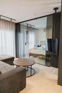 uma sala de estar com um sofá, uma televisão e uma cama em ID Residences 201 em Volos