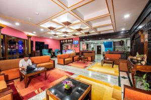 a man sitting in a hotel lobby with a laptop at Hotel Nirvana by Luxury International in Bhairāhawā