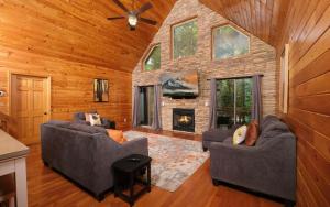 a living room with two couches and a fireplace at Shady Creek in Gatlinburg