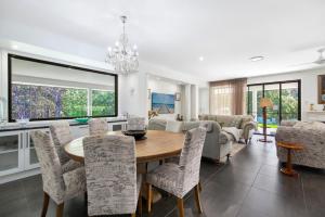 a dining room and living room with a table and chairs at Casa Bella 3 Bedroom in Coffs Harbour