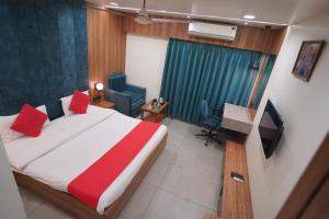 甘德希罕Hotel Gokul的一间卧室，配有一张床、一张书桌和一台电视 更多22张照片