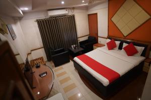 甘德希罕Hotel Gokul的一间带床和椅子的酒店房间