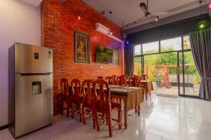 a dining room with a table and a refrigerator at Angkor Rithy Residences in Phumi Ta Phul