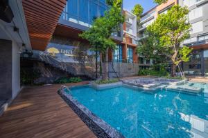 a swimming pool in front of a building at Richmann Resort Hotel Hatyai in Hat Yai +222 photos