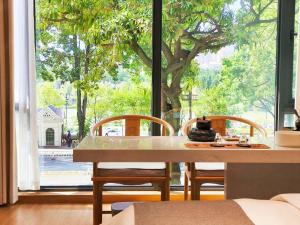 uma sala de jantar com mesa e cadeiras e uma grande janela em Ming-Sanshui Gleam B&B em Fuqing