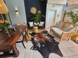 een woonkamer met een houten tafel en stoelen bij Hillton Manor Guest House in Richards Bay