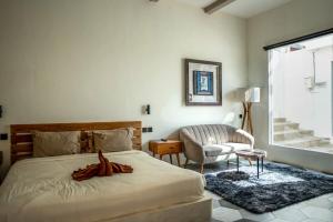 une chambre avec un lit, une chaise et une fenêtre dans l'établissement Spacious Design Villa 3bd, à Canggu 33 autres photos