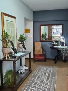 リチャーズ・ベイにあるHillton Manor Guest Houseの青い壁の客室で、テーブルと鏡が備わります。