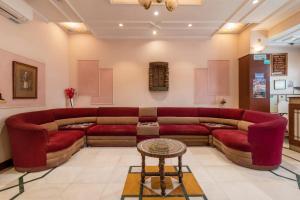 a living room with a red couch and a table at Treebo Trend Natraj Jaipur in Jaipur