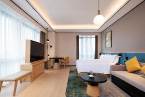 um quarto de hotel com uma cama e um sofá em Hilton Garden Inn Nanchang em Nanchang