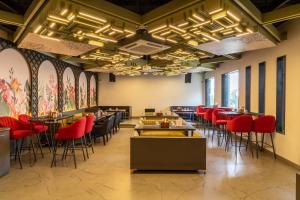 a dining room with tables and red chairs at Treebo Trend Natraj Jaipur in Jaipur