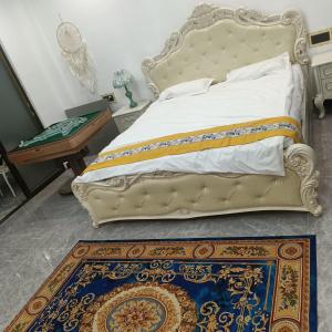 a bedroom with a bed and a rug on the floor at Minsheng Apartment in Guangzhou