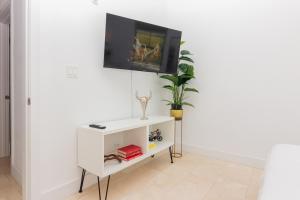 a white cabinet with a tv on a wall at Home Miami Downtown - 5 minutes from Wynwood & Port - near Beach in Miami
