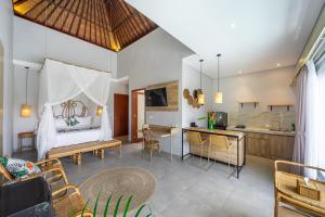 a room with a bed and a kitchen with a table at Kulta Villa Bali in Munggu