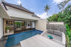 a villa with a swimming pool and a house at Kulta Villa Bali in Munggu