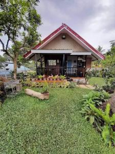 a house with a large yard in front of it at JHULLIE’S BREEZY HUT in Tagaytay