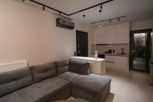 een woonkamer met een bank en een keuken bij ID Residences 203 in Volos