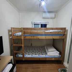 Joy Guesthouse في سول: سريرين بطابقين في غرفة