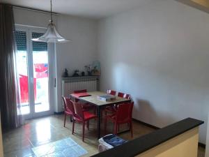 a dining room with a table and red chairs at Bed'n Fast... Always ready. Appartamento in Altare