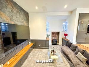 a living room with a couch and a tv at Beautiful Detached Villa - Jacuzzi Bath - Parking in Manchester
