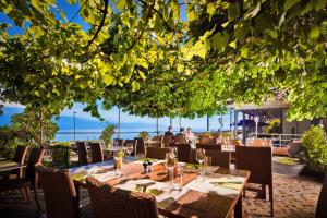 - un restaurant avec une table et des chaises offrant une vue sur l'océan dans l'établissement Auberge de la Gare, à Grandvaux