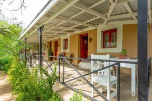 a porch of a house with a table and chairs at Bella de Karoo in Calitzdorp