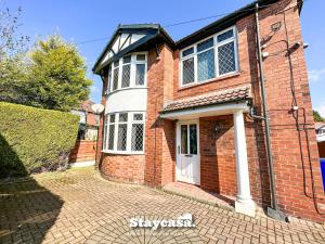 a brick house with a white door on a brick driveway at Beautiful Detached Villa - Jacuzzi Bath - Parking in Manchester
