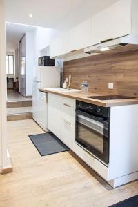 cocina con armarios blancos y fogones en L'Escapade-Hypercentre-parking privé-refait à neuf, en Châteauroux