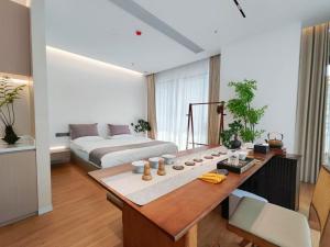 um quarto com uma cama e uma mesa num quarto em Ming-Sanshui Gleam B&B em Fuqing