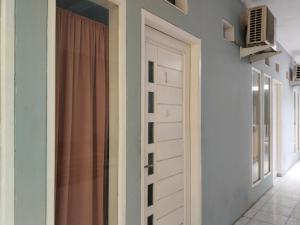 una porta in una stanza con finestra e tenda di SMAN House powered by Cocotel a Bekasi