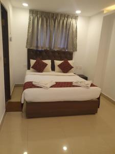 a bedroom with a large bed with a window at Earth Inn in Chennai