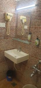 a bathroom with a sink and a brick wall at Earth Inn in Chennai