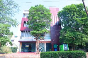 um edifício com uma árvore em frente em Green View Residency em Greater Noida