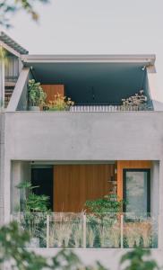 a house with a balcony with plants on it at 珍友愛J Youai House -台南包棟民宿-2-8人包棟城市景觀住宿 in Tainan